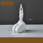 White ceramic sculpture of a person in a yoga pose with measurements on a gray background
