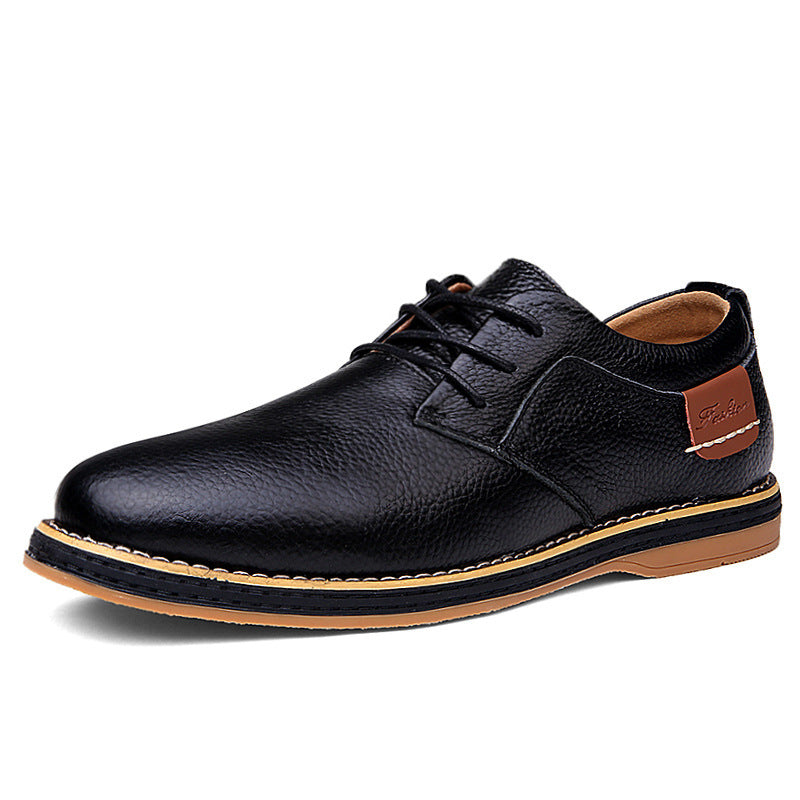 Black leather shoe with brown accents on a white background