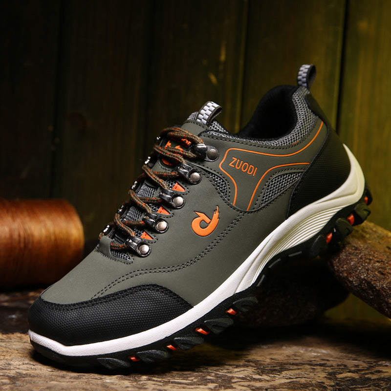 Gray and black sneaker with orange accents on a wooden surface