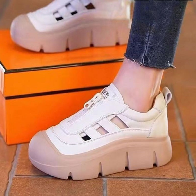 White and beige sneakers worn with orange box in the background