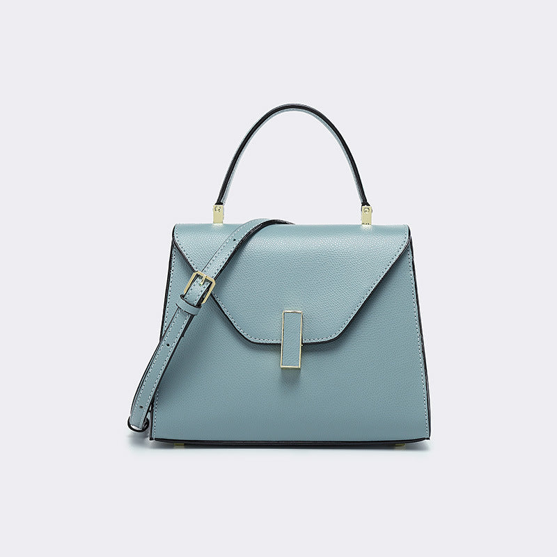 Light blue handbag with a strap on a light gray background