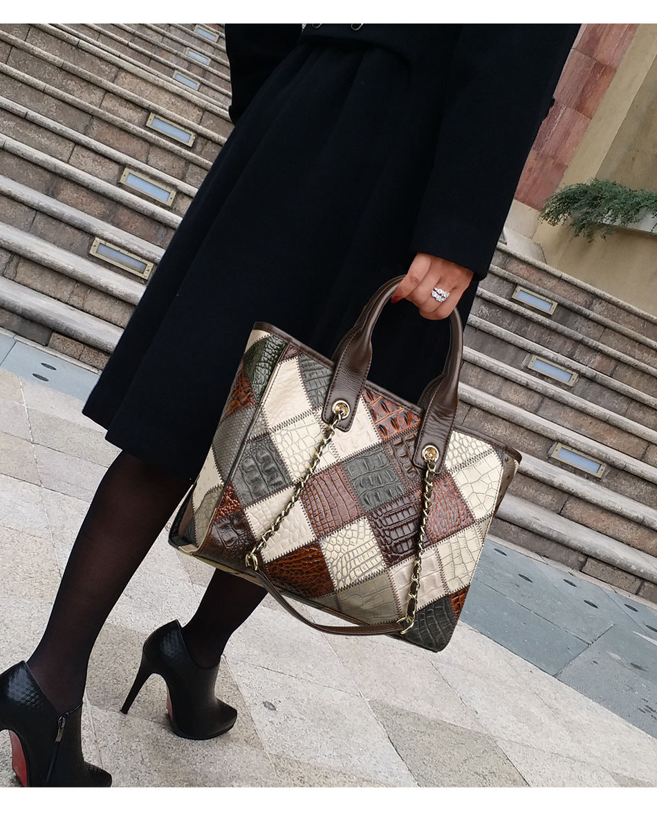 Person holding a patchwork handbag with a building in the background
