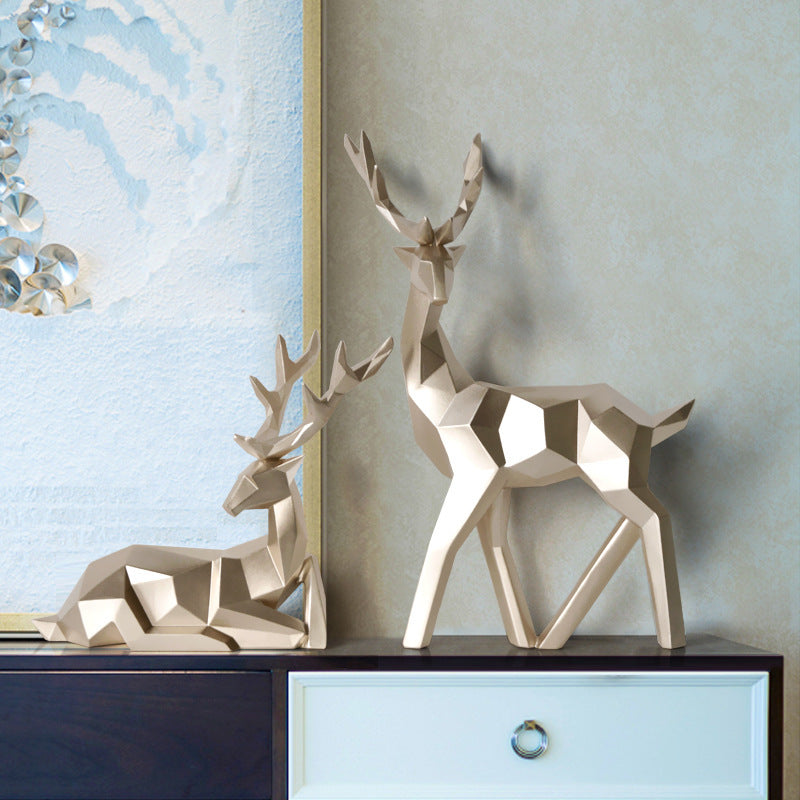 Geometric deer sculptures on a dresser with a decorative mirror in the background