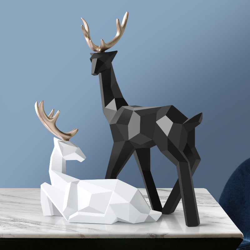 Black and white deer figurines on a marble surface with a blue background
