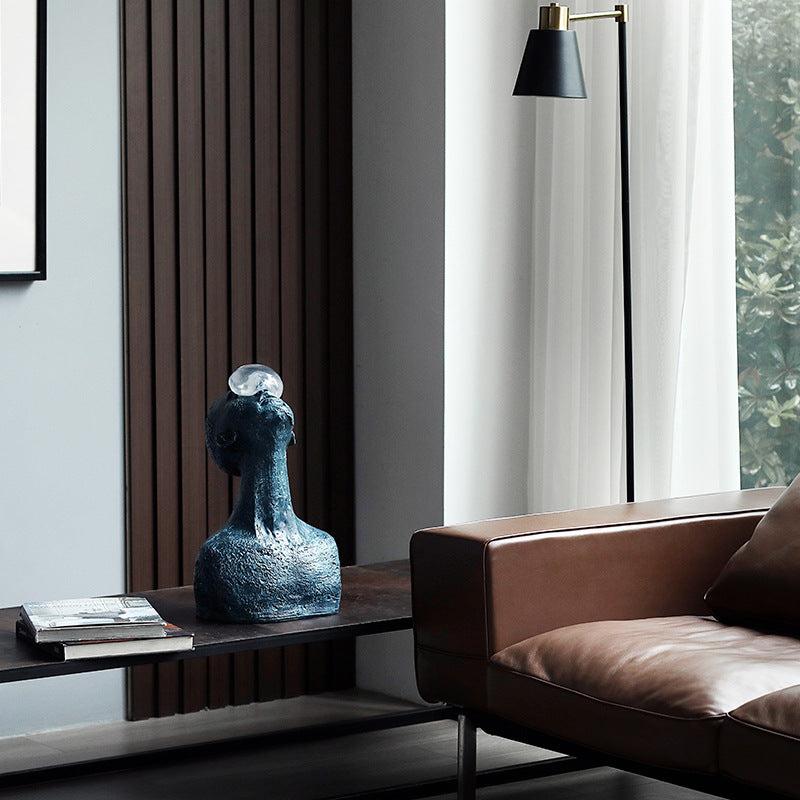 Modern living room with a blue sculpture on a side table and a brown sofa.