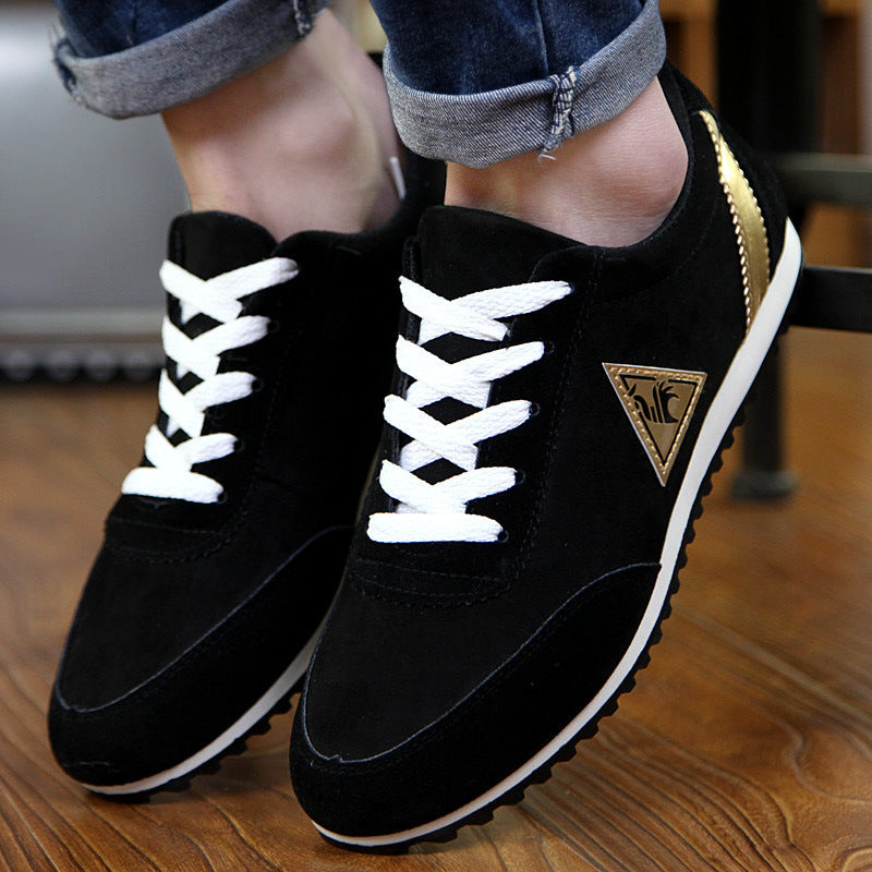 Black sneakers with white laces on a wooden floor