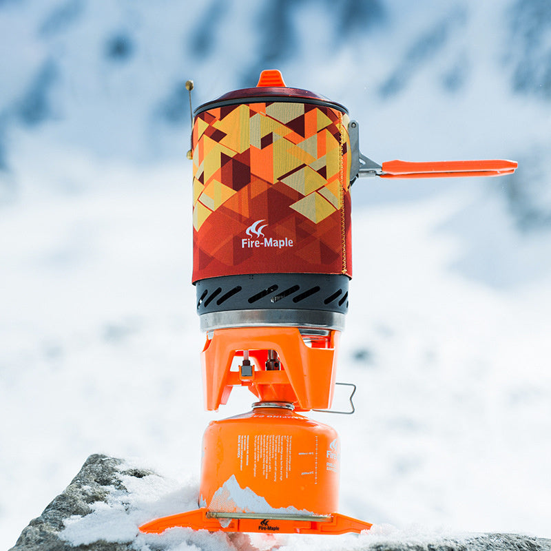 Orange camping stove with geometric pattern on a snowy background