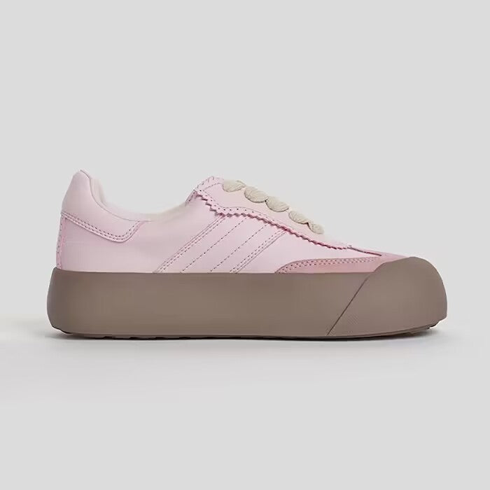 Pink sneaker with a brown sole on a light gray background