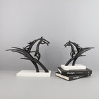 Two black horse sculptures on white bases against a gray background