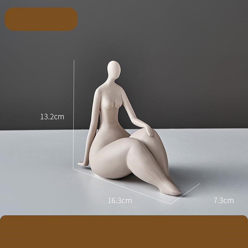 Ceramic sculpture of a sitting figure with dimensions indicated on a gray background