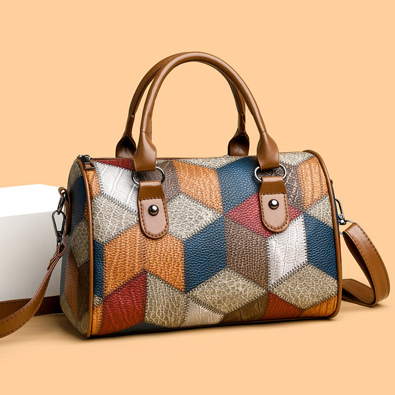 Multicolored patchwork handbag with brown handles and strap on a beige background