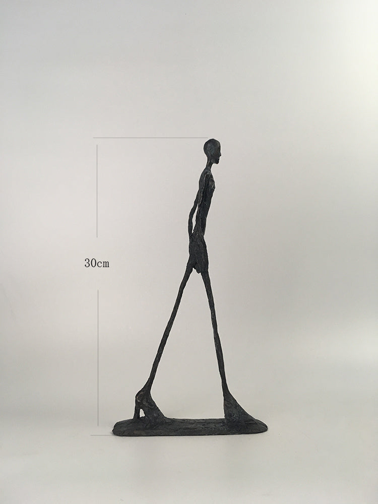 Black abstract sculpture of a figure on a white background with measurement label