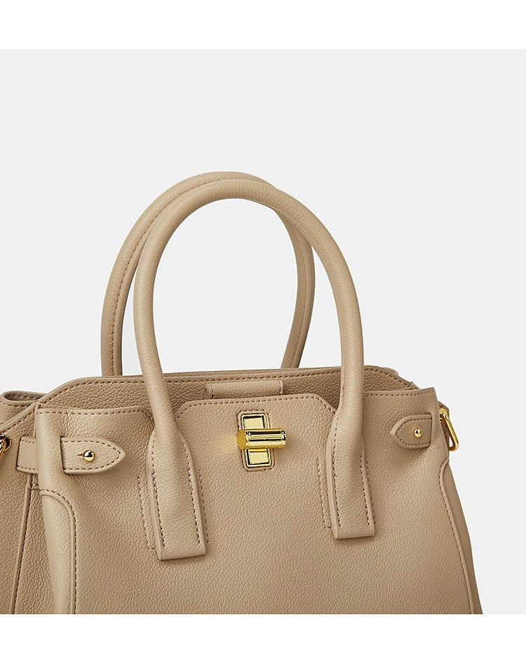 Beige handbag with gold accents on a light gray background