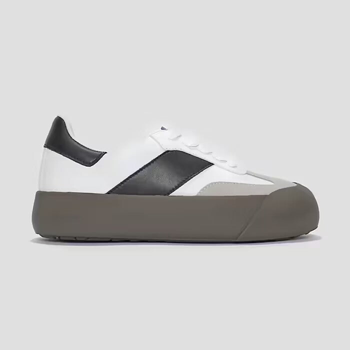 White and black sneaker with gray sole on a light gray background