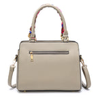 Beige handbag with a colorful handle on a white background