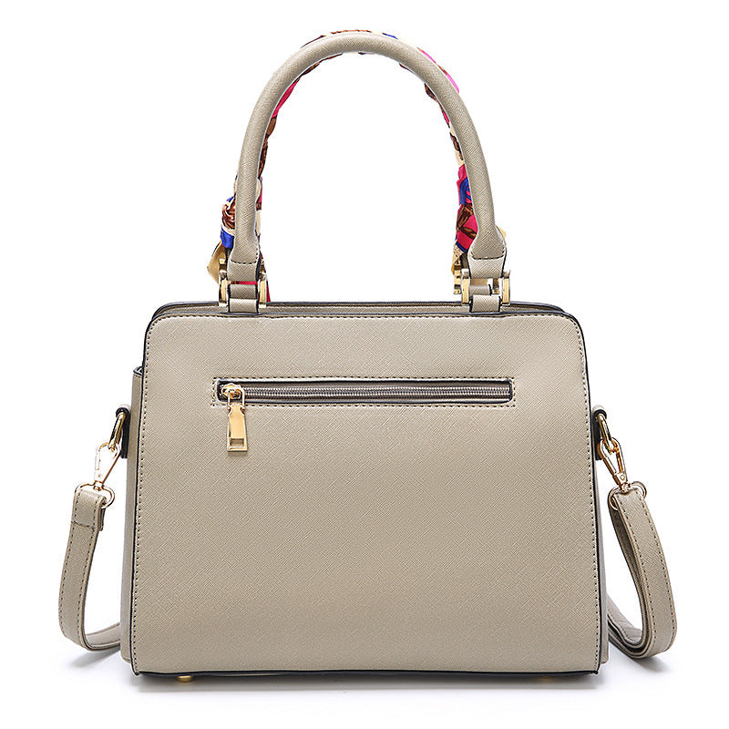 Beige handbag with a colorful handle on a white background