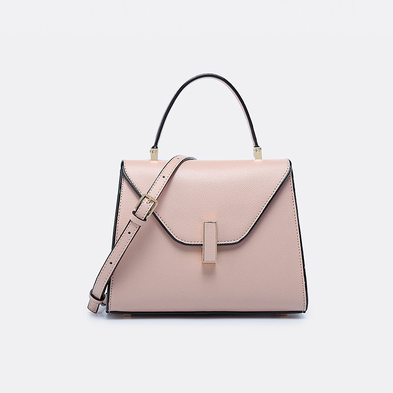 Pink handbag with black accents on a light gray background