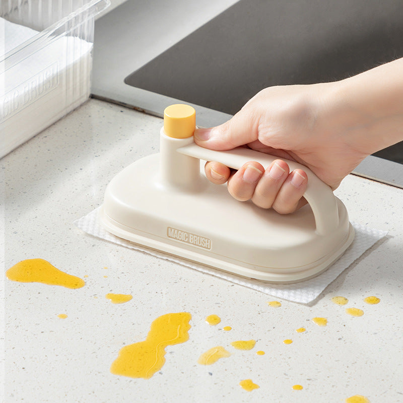 Hand holding a beige and yellow cleaning tool on a surface with yellow stains.