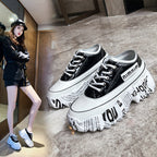 Black and white sneakers with text design on a gray floor.