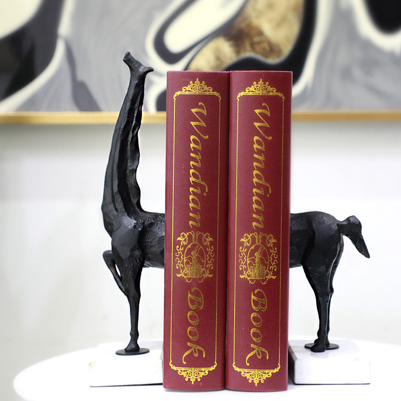 Two red books titled 'Wandian Book' with decorative gold text, flanked by black dog figurines on a white surface.
