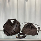 Brown woven handbag, drawstring pouch, and belt on a light gray background