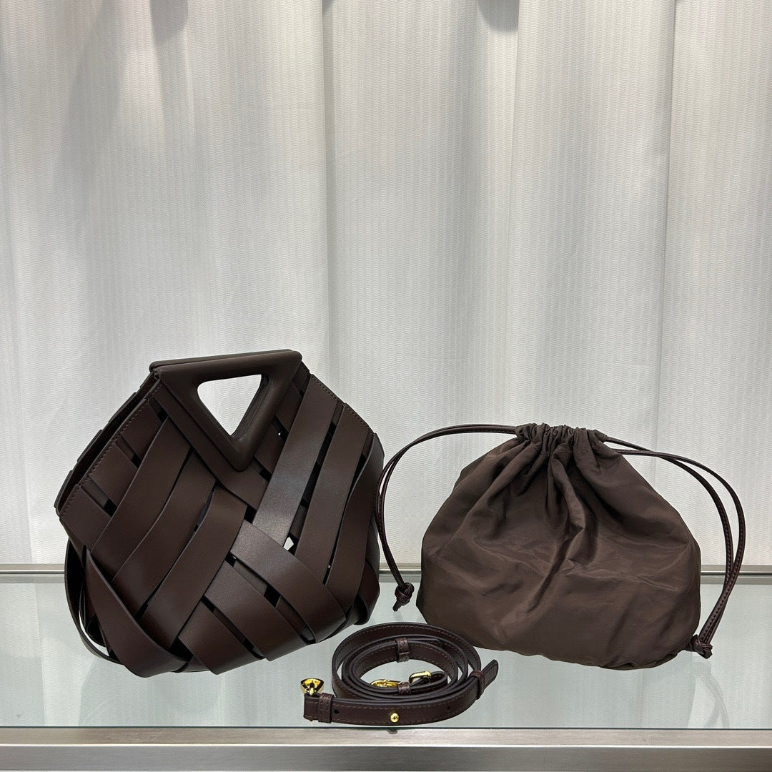 Brown woven handbag, drawstring pouch, and belt on a light gray background