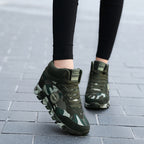 Green camouflage hiking boots worn on a tiled pavement