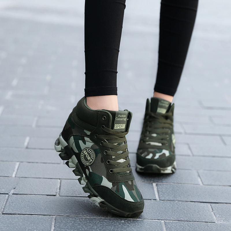 Green camouflage hiking boots worn on a tiled pavement