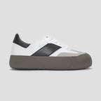 White and black sneaker with a gray sole on a light gray background