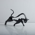 Two black metal animal sculptures on a white background