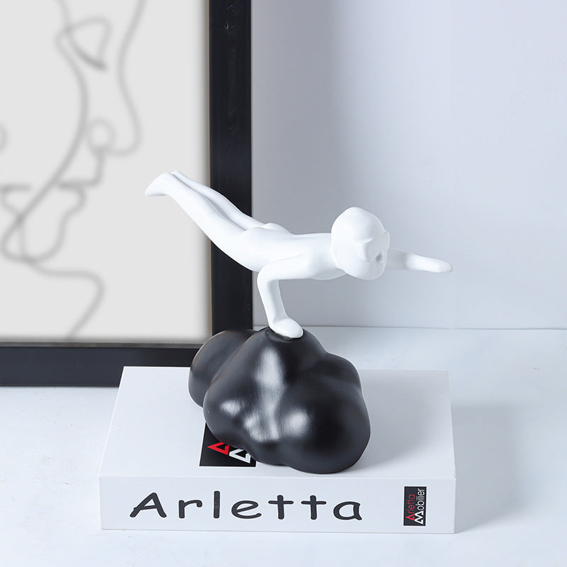 Decorative sculpture with a white figure on a black base, branded 'Arletta', on a white surface.
