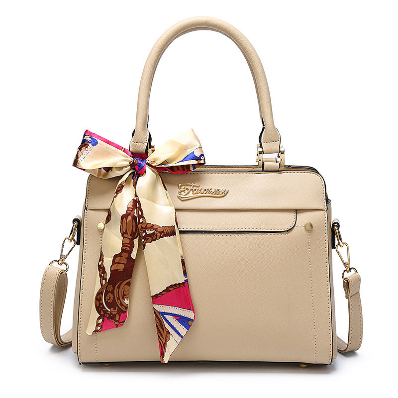 Beige handbag with a colorful bow and visible brand logo on a white background