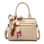 Beige handbag with a colorful bow and visible brand logo on a white background