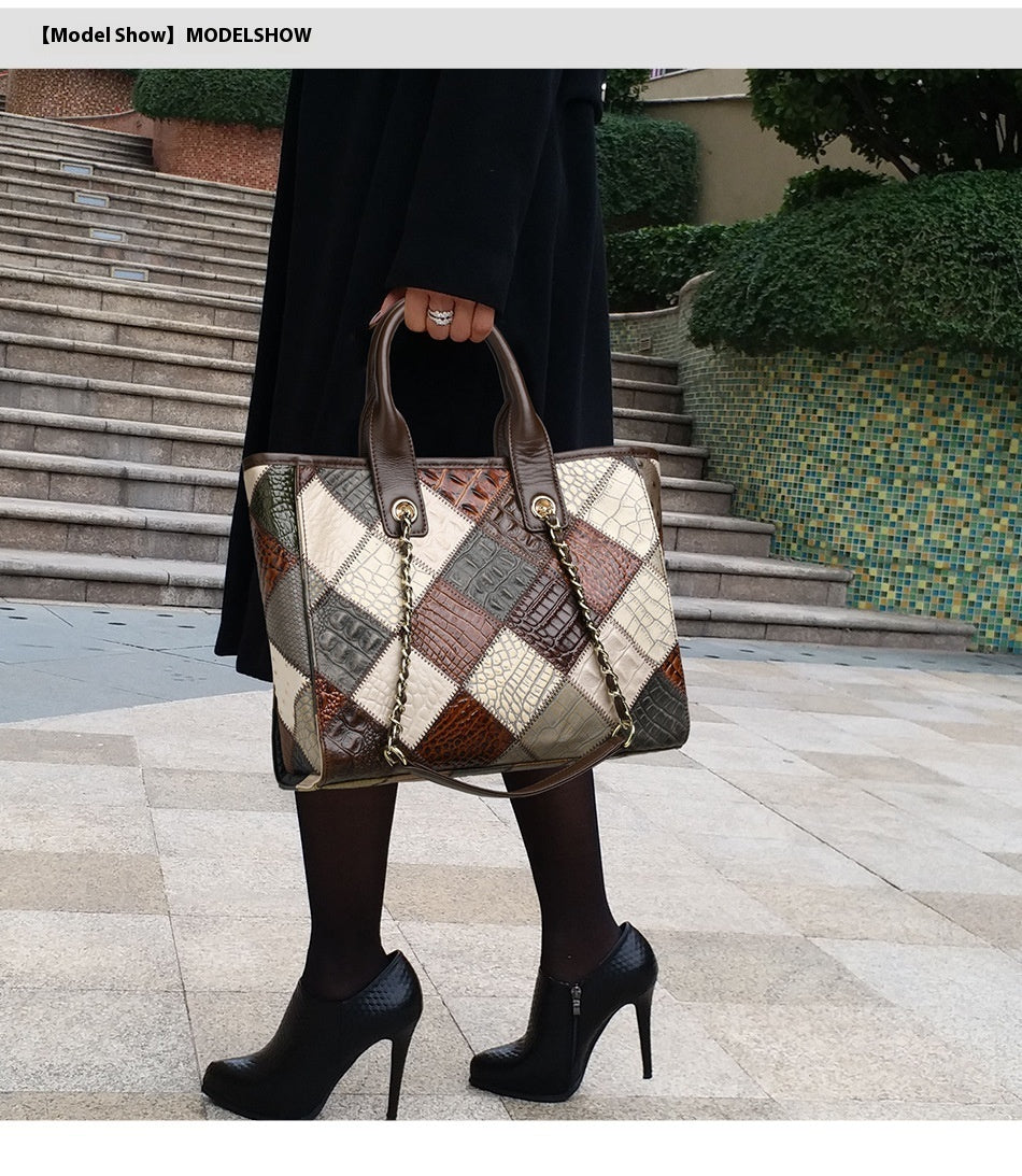 Person holding a patchwork handbag with a building in the background