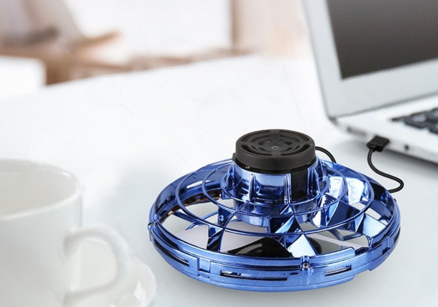 Blue personal fan on a desk next to a laptop and mug