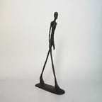 Abstract sculpture of a humanoid figure on a white background