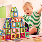 Child playing with colorful magnetic building blocks on a light surface.