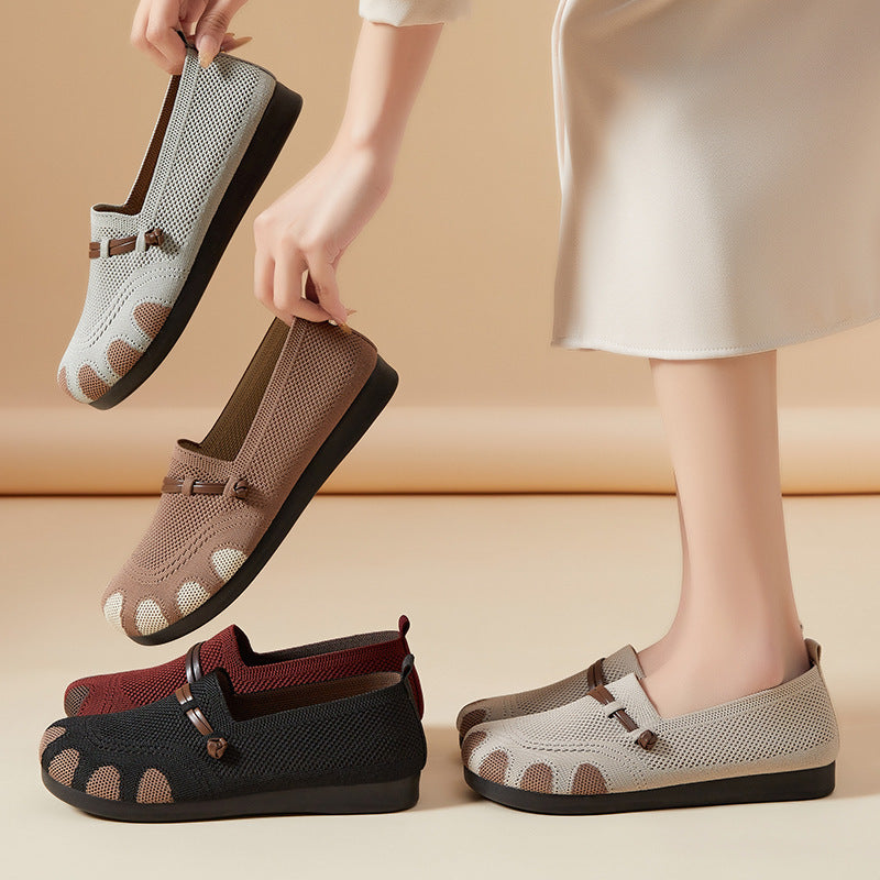 Person wearing and holding a pair of mesh shoes on a beige background