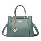 Green handbag with gold accents and a brand logo on a white background