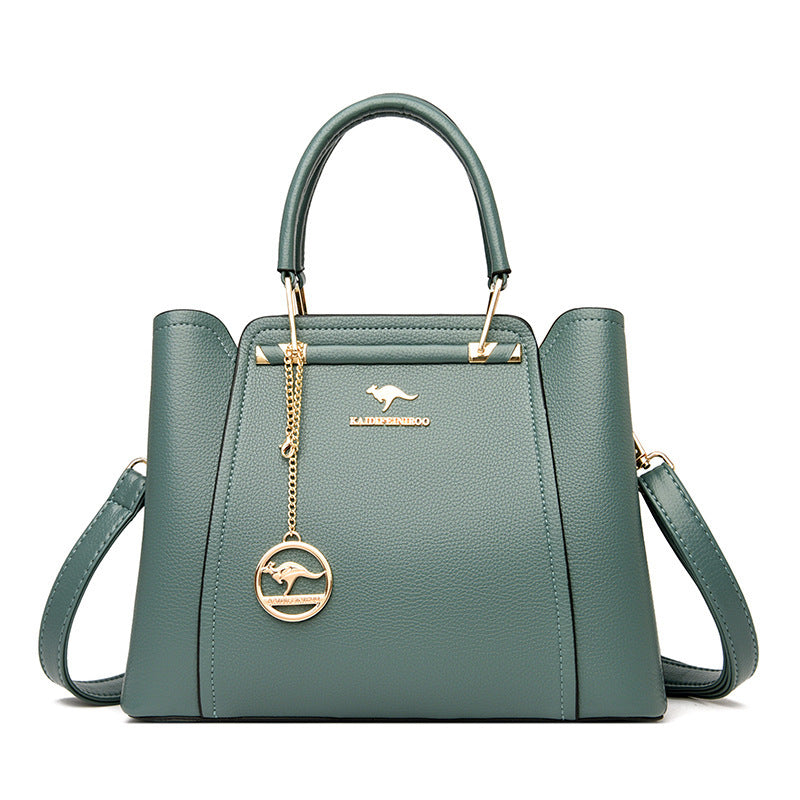 Green handbag with gold accents and a brand logo on a white background
