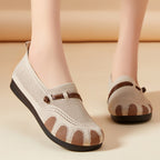 Beige mesh shoes with brown accents worn by a person on a beige background