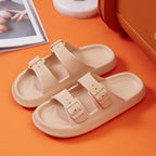 Beige sandals with buckles on an orange surface