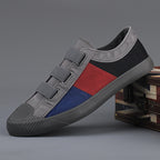 Multicolored sneaker with gray, red, and blue design on a gray background