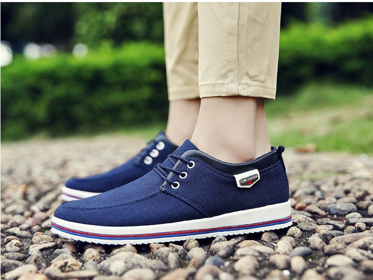 Blue casual shoes worn on a rocky ground with a blurred green background