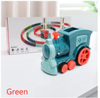 Toy train with green engine and red wheels on a white surface, with packaging in the background.