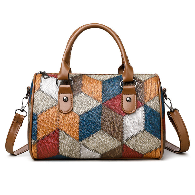 Multicolored patchwork handbag with brown handles and strap on a white background