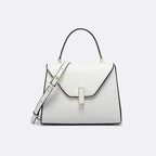 White handbag with black accents on a light gray background