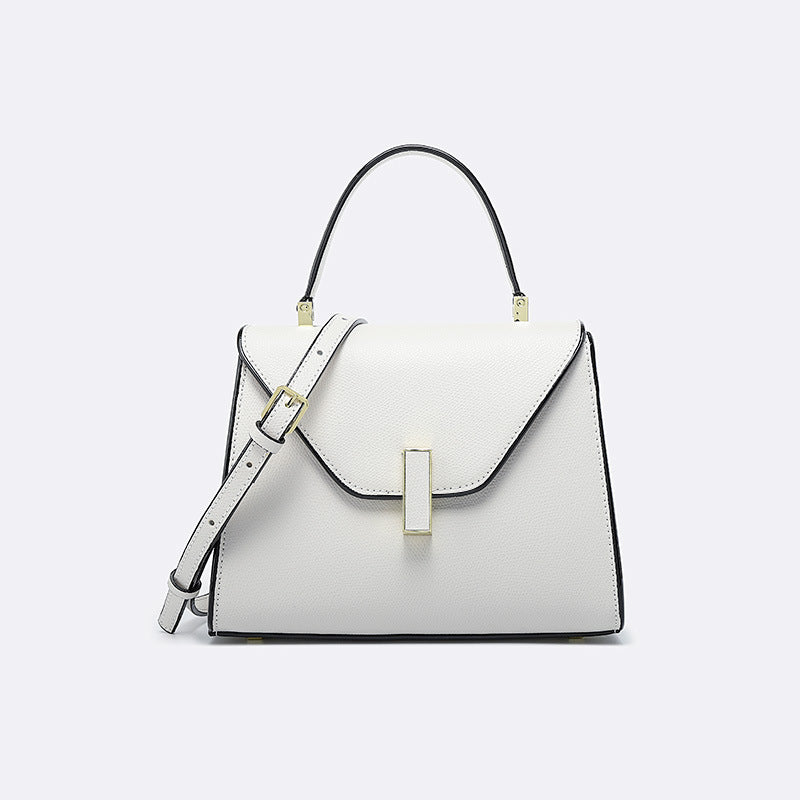 White handbag with black accents on a light gray background
