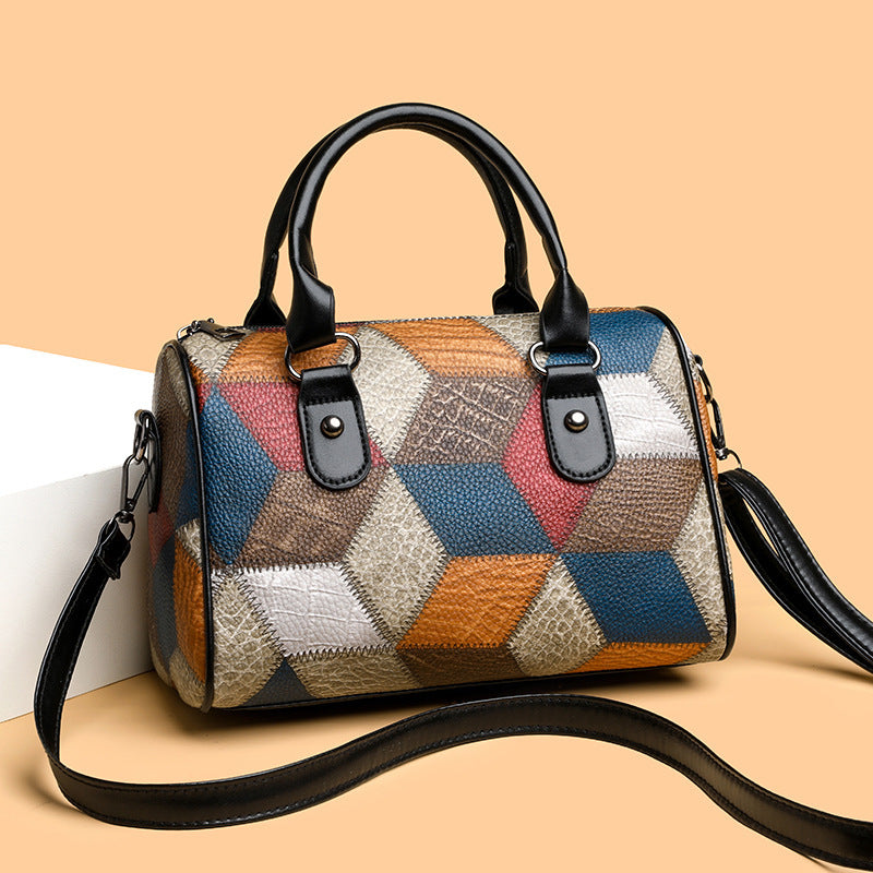 Multicolored patchwork handbag with black handles and strap on a beige background