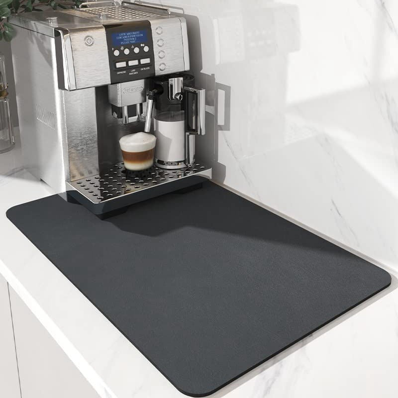 Espresso machine with a cup of coffee on a black mat in a kitchen setting